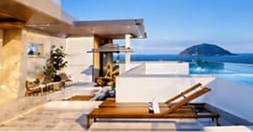 Perspectiva do sky lounge com piscina e espreguiçadeiras de frente para o mar
